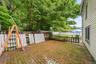 Brick patio area surrounded by mature trees.