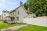 Side exterior view featuring the driveway, lawn and privacy fencing.