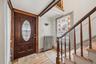 MAIN HOUSE - Front entrance featuring a decorative glass door, original-style woodwork and staircase.