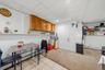 APARTMENT - Kitchen and dining area with wood cabinetry and counter seating.