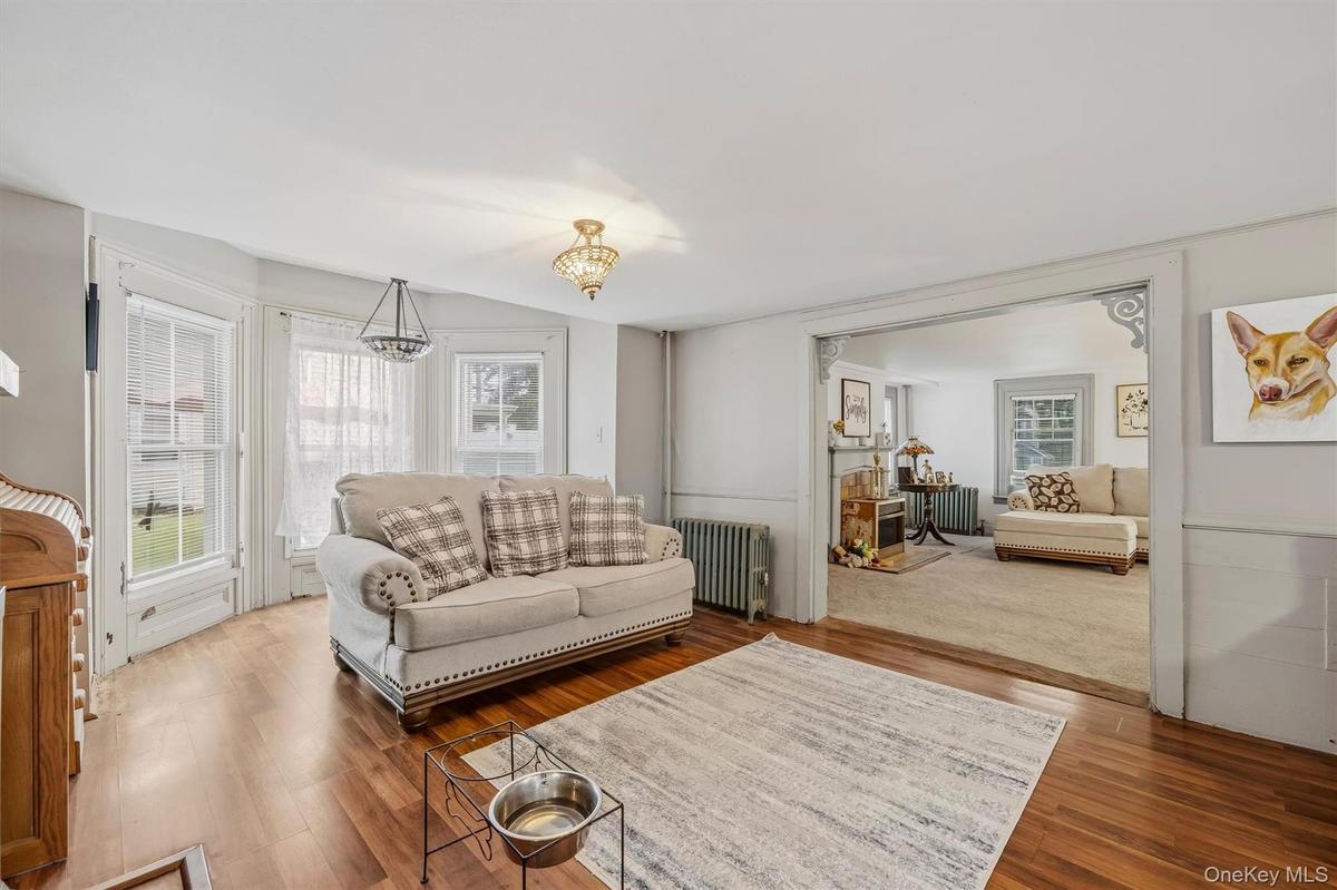 MAIN HOUSE - Flexible sitting and dining area with multiple windows and a wide opening to the adjoining living room.