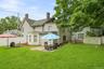 Rear view of the home showing the patio areas and open lawn.