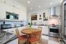 Apt. 4-B - Kitchen with recessed LED lighting, integrated appliances, full-height cabinetry, granite counters and cork flooring.