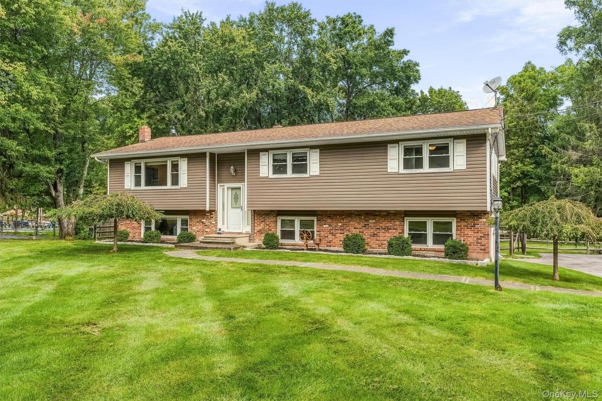 Split-level residence featuring a brick foundation and siding exterior