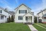 Two-story residence featuring light-colored siding and a covered front porch