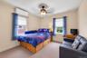 Neutral wall tones with crown molding, ceiling fan, and carpeted flooring