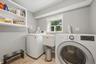 Laundry area featuring a utility sink, open shelving, and a window