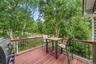 Expansive outdoor deck with red-stained wood flooring and black metal railings