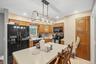 Kitchen featuring wood cabinetry, a center island with seating, a black side-by-side refrigerator, a black microwave, and a black range