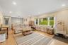 Recessed lighting, crown molding, wood-finish flooring, a decorative pendant light, and a large picture window