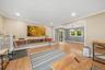 Hardwood flooring, recessed lighting, crown molding, and a built-in entertainment unit with wood-finish shelving