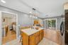 Kitchen island with wood-finish cabinetry and light-toned countertop, complemented by modern overhead lighting