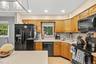 Kitchen featuring wood-finish cabinetry, black appliances, recessed lighting, and a tile backsplash