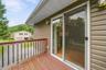 Exterior decking with wood railings, sliding glass door, and vinyl siding