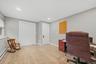 Recessed lighting, wood-finish flooring, two panel doors, window with roller shade, and light gray wall paint
