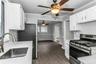 Kitchen featuring white cabinetry, light countertops, wood-finish flooring, and a stainless steel range