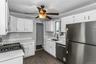 Kitchen featuring white cabinetry, light countertops, wood-finish flooring, stainless steel appliances, and a gas range
