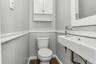 Bathroom featuring a wall-mounted floating sink, chrome faucet, and white wall cabinetry