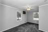 Spacious room featuring light gray walls, dark gray carpeting, and white trim