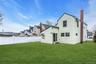 Expansive green lawn with a white privacy fence