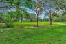 Expansive green space featuring mature trees and lush landscaping