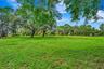 Expansive lawn area with mature trees and natural landscaping