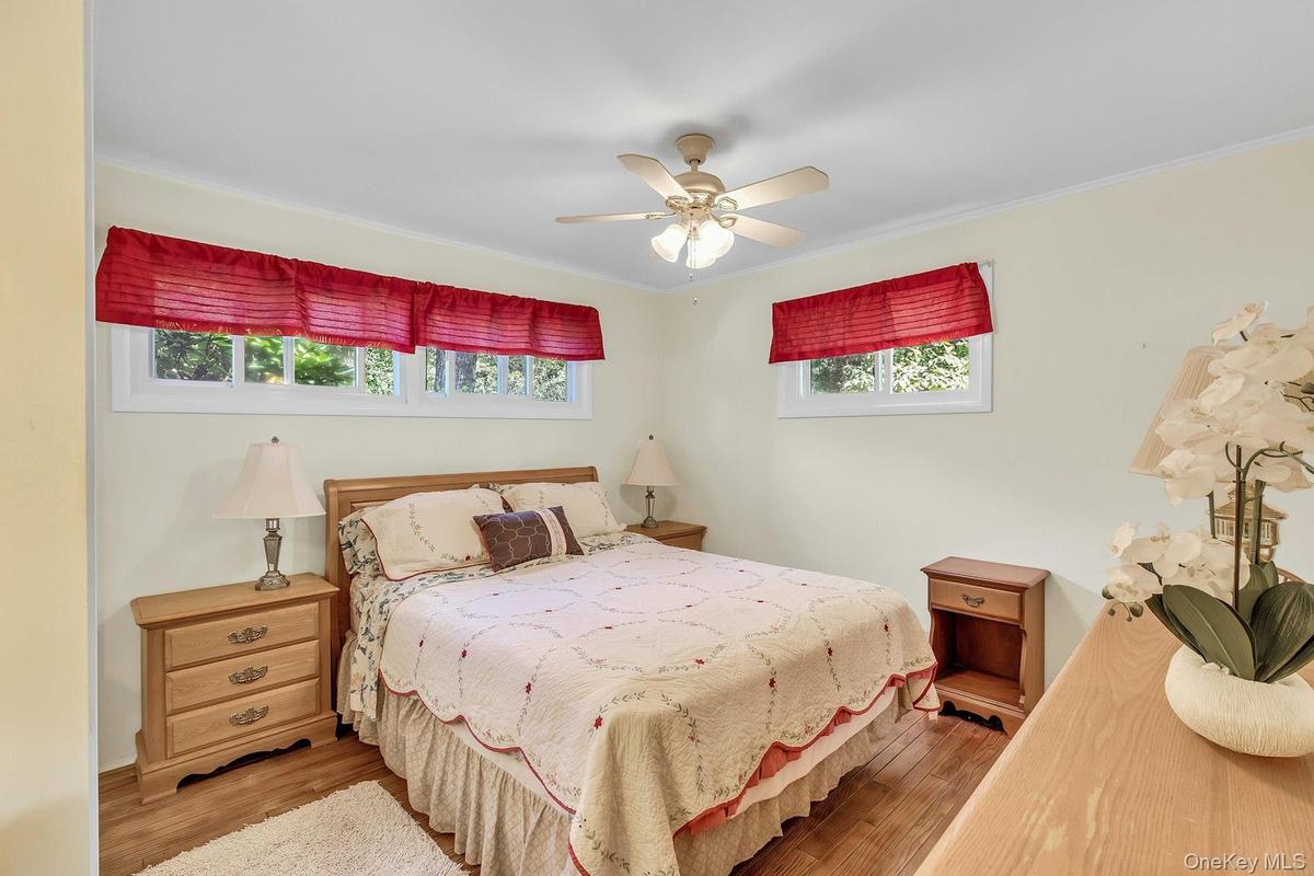 Recessed windows, wood-finish flooring, and a ceiling fan with integrated lighting