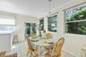 Tile flooring, multiple windows, sliding glass door, crown molding, and a pendant light fixture