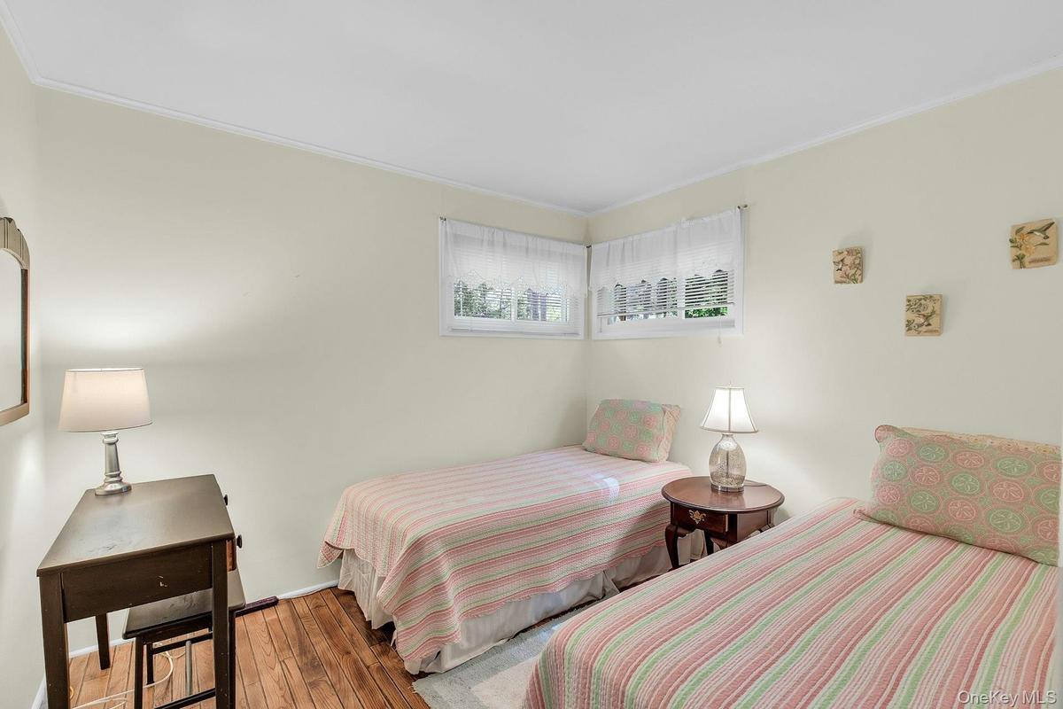 Hardwood flooring, crown molding, double windows, and light-toned wall finishes