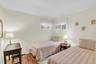 Hardwood flooring, crown molding, double windows, and light-toned wall finishes