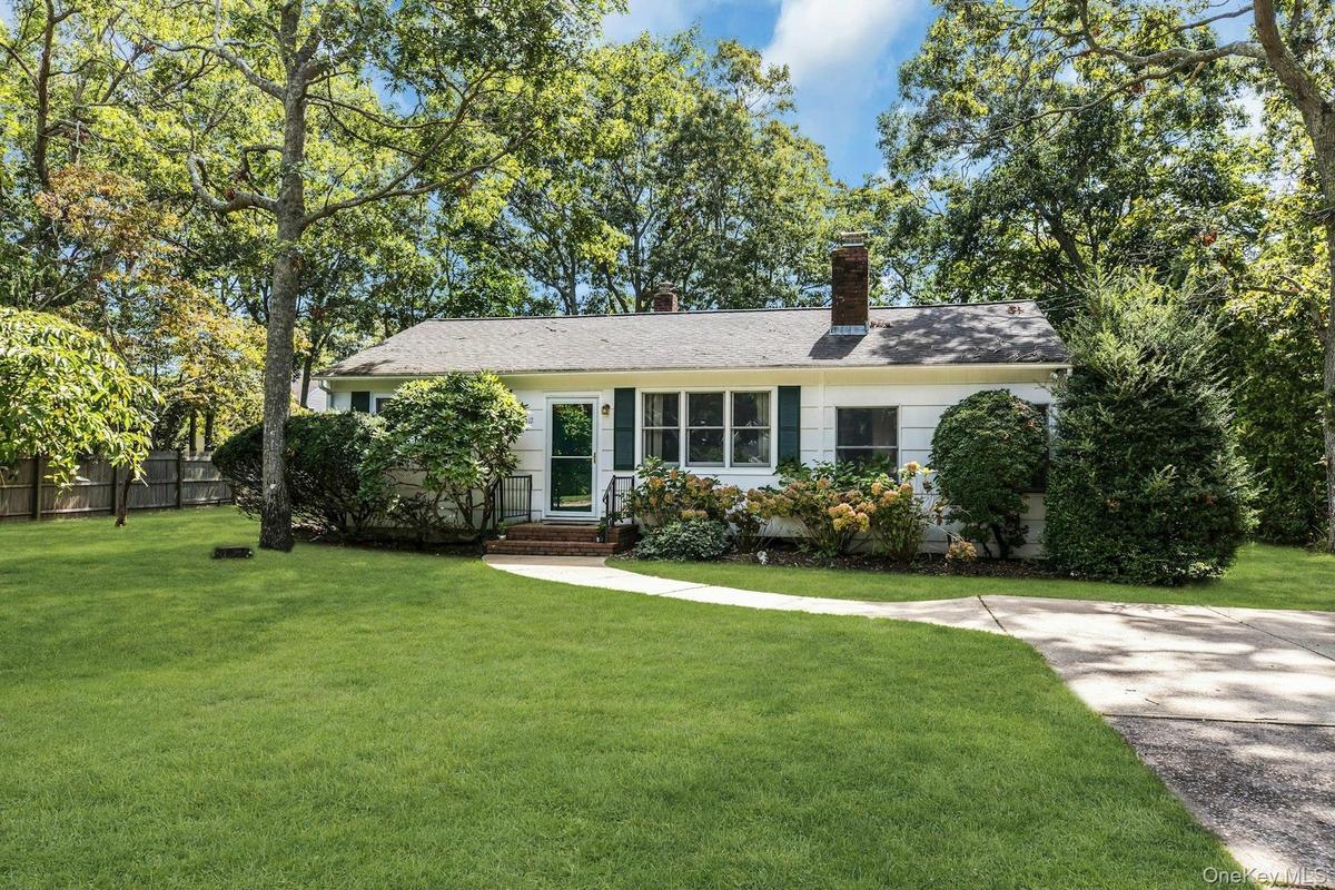 Ranch-style exterior with white siding, dark green shutters, and a gray shingle roof