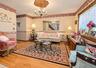 Hardwood flooring with decorative inlay, chandelier with ornate ceiling medallion, decorative wall coverings, window with lace curtain, and built-in w