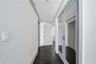 PRIMARY BEDROOM HALL / SECOND CLOSET. Mirror covered double doors has second closet in bedroom hall.