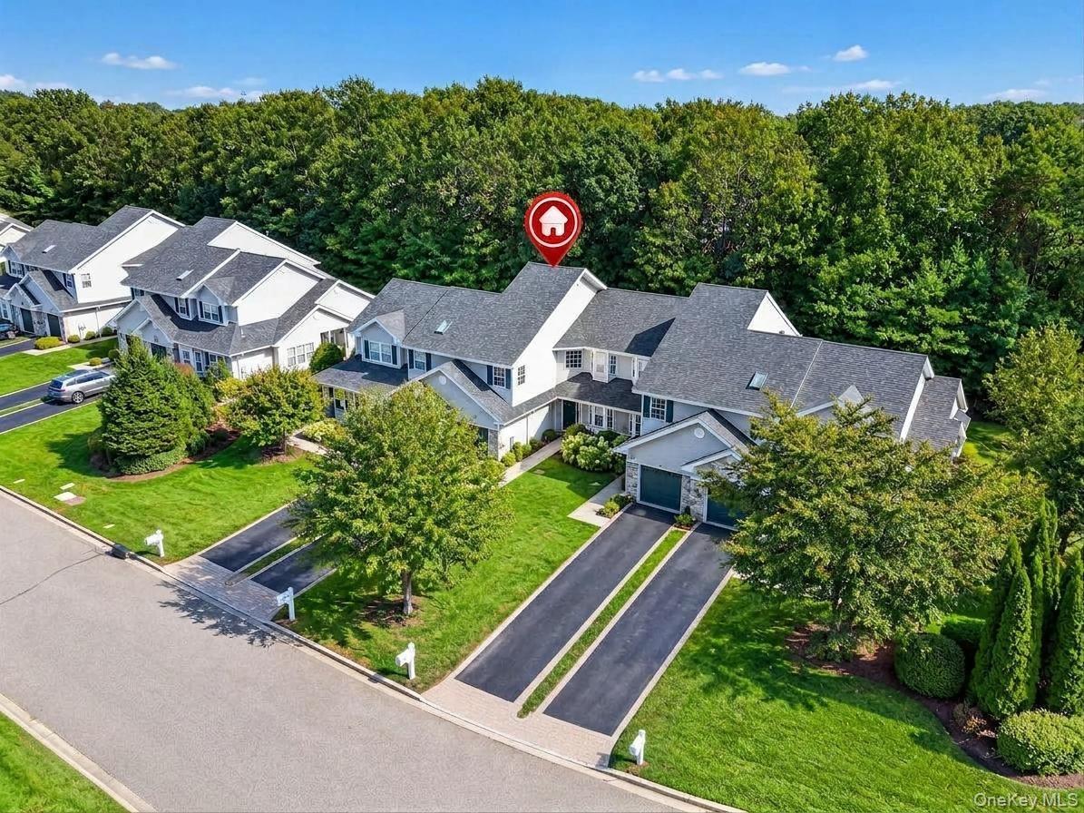 Aerial view of unit with attached one car garage and long driveway