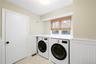 Laundry room featuring wainscoting, independent washer and dryer, and a decorative wall