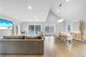 Living room featuring high vaulted ceiling, healthy amount of natural light, recessed lighting, light wood-style flooring, and a chandelier