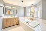 Primary bathroom with double vanity, tub and shower