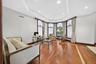 Recessed lighting, crown molding, tray ceiling, hardwood flooring with inlaid detailing, and large bay windows