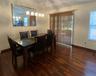 Wood-finish flooring throughout, with a framed wall mirror and overhead linear chandelier