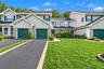 Front view with expansive driveway and attached garage