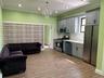 Open-concept living space featuring wood-finish flooring, recessed lighting, and a crystal chandelier