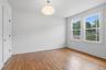 Hardwood flooring, two windows, recessed lighting, white walls, and a white interior door