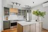 Kitchen featuring a center island, stainless steel appliances, wood-finish flooring, white countertops, and track lighting
