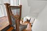 Hardwood flooring, wood newel posts, and dark balusters accent the staircase