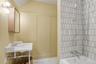 Corner vanity with a marble top, chrome fixtures, and wood-finish medicine cabinet