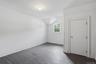 Painted wood flooring, white walls, angled ceiling, single window, interior door