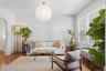 Hardwood flooring, arched doorway, large windows, ceiling-mounted light fixture, light gray wall color