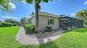 The right side of the home with paver walkway from the front to the pool area.