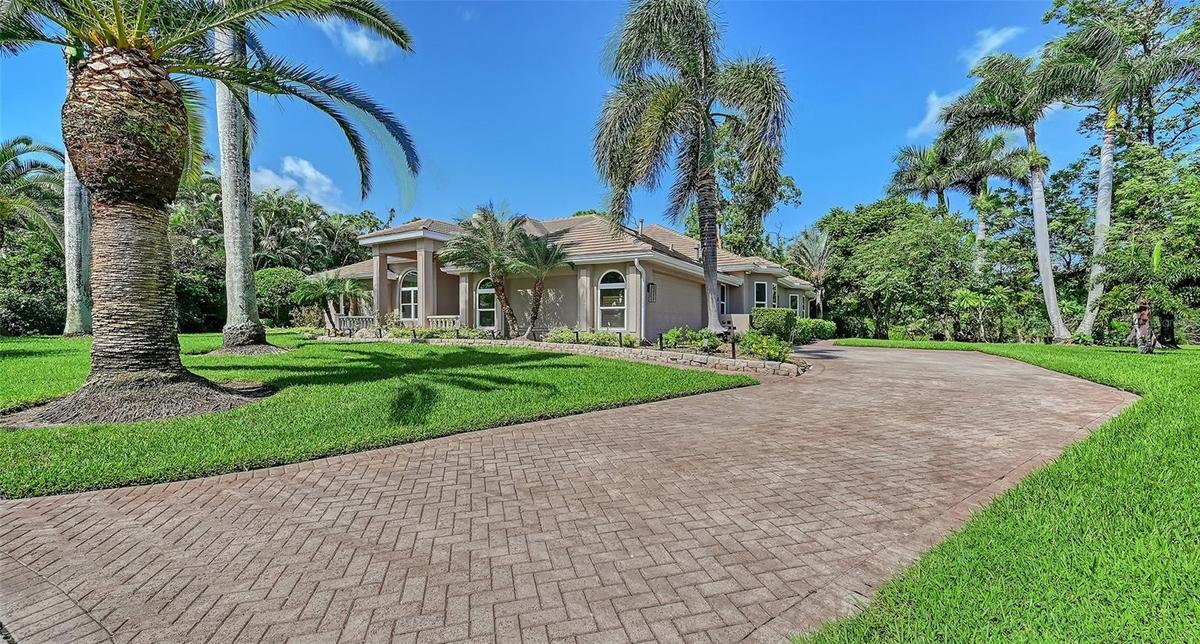 Long paver driveway with the side entry two-car garage.
