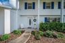 Covered entry and mature flowers and shrubs